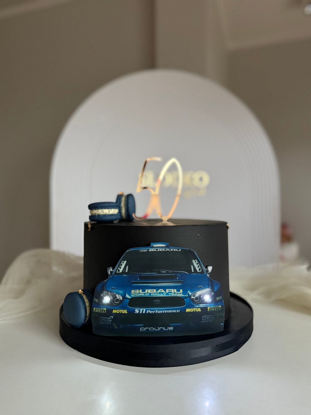 Blue Subaru sports car model displayed on black base with neon signs and headlights illuminated in background